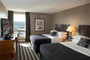 a hotel room with a large bed and a large window at Royal Hotel Regina, Trademark Collection by Wyndham in Regina