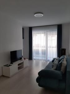 sala de estar con sofá y TV de pantalla plana en Rozsa 55 Appartment, en Budapest