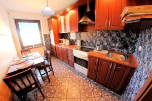 a kitchen with wooden cabinets and a table and a sink at Apartament Teresa in Łeba