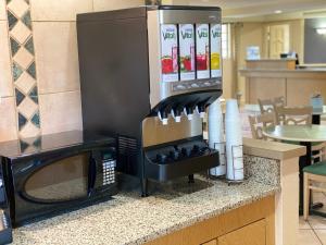 a kitchen counter with a stove with a microwave at La Quinta Inn by Wyndham Tyler in Tyler