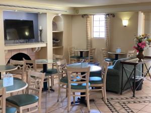 a restaurant with tables and chairs and a fireplace at La Quinta Inn by Wyndham Tyler in Tyler