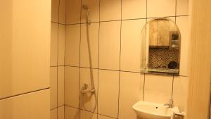 a bathroom with a shower and a sink and a mirror at Apartemen Grand Kamala Lagoon by Cheapinn in Bekasi