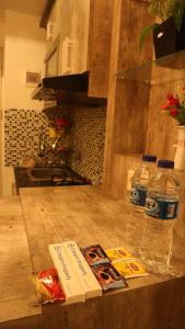 a kitchen counter with two bottles of water and food at Apartemen Grand Kamala Lagoon by Cheapinn in Bekasi