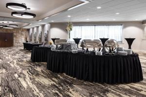 a room with black tables and chairs and a room with at Holiday Inn Hotel & Suites Des Moines-Northwest by IHG in Urbandale