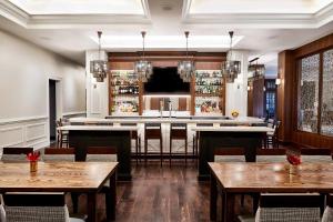 a restaurant with wooden tables and a bar at The Inn at Elon in Elon