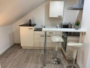 eine Küche mit einer Theke und Hockern darin in der Unterkunft Ossiach Apartment 1 in Heiligen Gestade