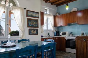 a kitchen with a table with blue chairs in it at ECO Balcony to the Aegean in Stení