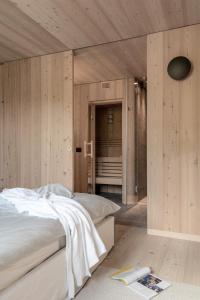 een slaapkamer met 2 bedden en houten wanden bij Larix Lodge in La Villa