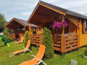 a cabin with chairs and flowers in front of it at Arcada in Jarosławiec