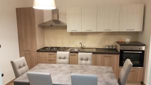 a kitchen with a table and chairs and a stove at Apartment Atlantic Roseto Beach in Roseto degli Abruzzi