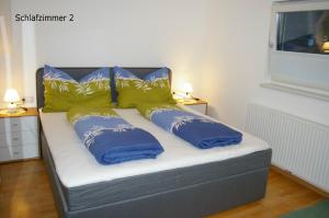 uma cama com almofadas azuis e amarelas em Imsterberger Auszeit em Imsterberg