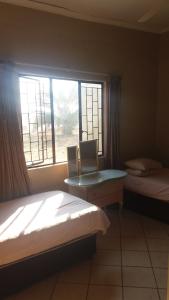 1 Schlafzimmer mit 2 Betten und einem Fenster in der Unterkunft Abuelita Guesthouse - Room 2 in Lephalale