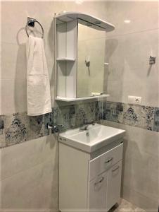 a white bathroom with a sink and a mirror at Griboedov 13 in Tbilisi City +28 photos