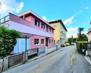 ein rosa Haus an der Straßenseite in der Unterkunft Studio apartment Margarita in Opatija