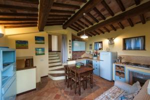 a kitchen with a wooden table and a refrigerator at Podere Piazza Siena in Siena