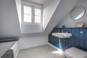 a bathroom with a sink and a toilet and a window at The Sands Sheringham in Sheringham
