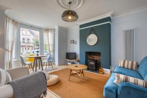 a living room with a blue couch and a table at The Sands in Sheringham