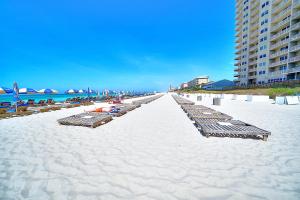 a beach with lounge chairs and umbrellas on it at Amazing Sunset Oceanfront Condo in Panama City Beach