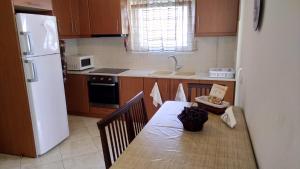 a kitchen with a table and a white refrigerator at Classic-style apartment in Loutra Edipsou +8 photos