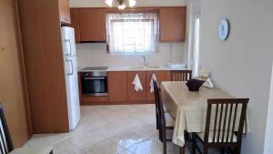 a kitchen with a table and a white refrigerator at Classic-style apartment in Loutra Edipsou