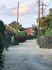 an empty road with a house in the background at Travelers House おーさんてぃん青空舎 in Taketomi