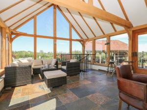 an open living room with a large conservatory with windows at Groomes Country House in Bordon