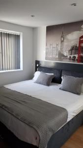 uma cama grande num quarto com uma fotografia na parede em Bell Gate House em Leicester