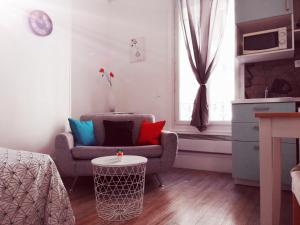 ein Wohnzimmer mit einem Stuhl und einem Tisch in der Unterkunft Studio dans un quartier résidentiel à Montrouge avec le métro à 2 min in Montrouge