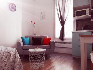 a living room with a chair and a table at Studio situé dans un quartier calme et résidentiel à Montrouge à seulement 2 minutes du métro in Montrouge +9 photos