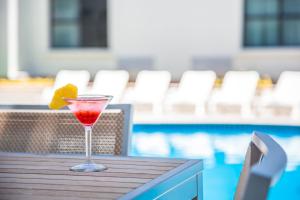 a drink sitting on a table next to a pool at Fiesta Inn Saltillo in Saltillo