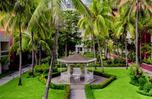 a gazebo in the middle of a lawn with palm trees at Gamma Tampico in Tampico