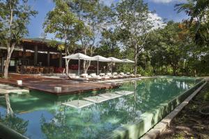 - une piscine avec des chaises et des parasols en face d'un bâtiment dans l'établissement The Explorean Cozumel All Inclusive, à Cozumel