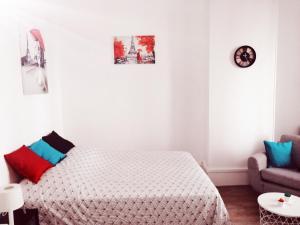 ein weißes Schlafzimmer mit einem Bett und einem Sofa in der Unterkunft Studio dans un quartier résidentiel à Montrouge avec le métro à 2 min in Montrouge