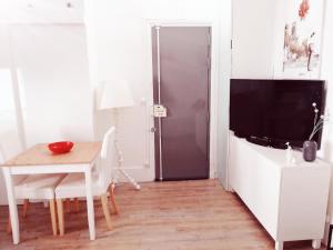 ein Esszimmer mit einem Tisch und einem TV in der Unterkunft Studio dans un quartier résidentiel à Montrouge avec le métro à 2 min in Montrouge