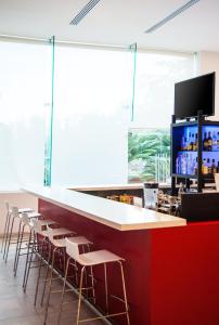 a bar with stools and a counter with a television at Fiesta Inn Culiacan in Culiacán