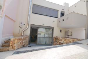 um edifício com uma porta de vidro e uma parede de pedra em Brand new Cozy Basement Apartment em Argostoli