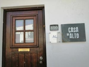 une porte en bois et un panneau sur un bâtiment dans l'établissement Casa do Alto - Benfeita, à Benfeita