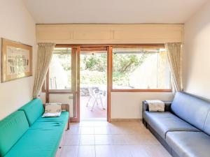 un soggiorno con 2 divani blu di Belvilla by OYO Le Mimose nr 11 a Punta Ala