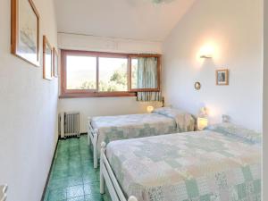 a room with three beds and a window at Belvilla by OYO Le Mimose nr 11 in Punta Ala