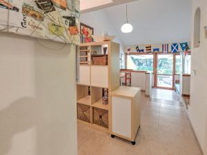 - une cuisine avec des placards blancs et une table dans une pièce dans l'établissement Belvilla by OYO Le Mimose nr 12, à Punta Ala