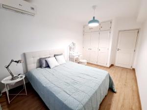 a white bedroom with a bed and a lamp at Central and New Fancy 2 Bedroom Apart.w/ 2 Wc in Faro