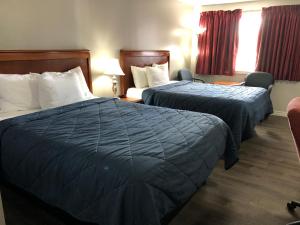a hotel room with two beds and two nightstands at Aquarius Motel in Perth