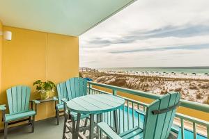 einen Balkon mit Tisch und Stühlen sowie Strand in der Unterkunft Pelican Isle Condominiums in Fort Walton Beach