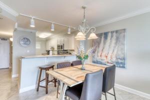 a kitchen and dining room with a wooden table and chairs at Sea Oats II in Fort Walton Beach