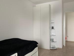 ein Schlafzimmer mit weißen Wänden und ein Bett mit einer schwarzen Decke in der Unterkunft Apartamenty Sunrise Kolobrzeg Podczele in Kołobrzeg