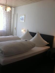 1 Schlafzimmer mit 2 Betten und weißen Kissen in der Unterkunft Gästehaus Ullmannshof in Kirchheim am Neckar