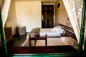 a hotel room with two beds and a chair at Pousada Flor da Serra in Cruzeiro