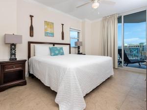 a bedroom with a large bed and a balcony at Waterscape A VIII in Fort Walton Beach