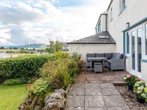 a patio with a table and chairs on the side of a house at Stag Cottage in Penrith
