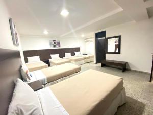 a room with several beds and couches in it at Hotel Arawak Upar in Valledupar